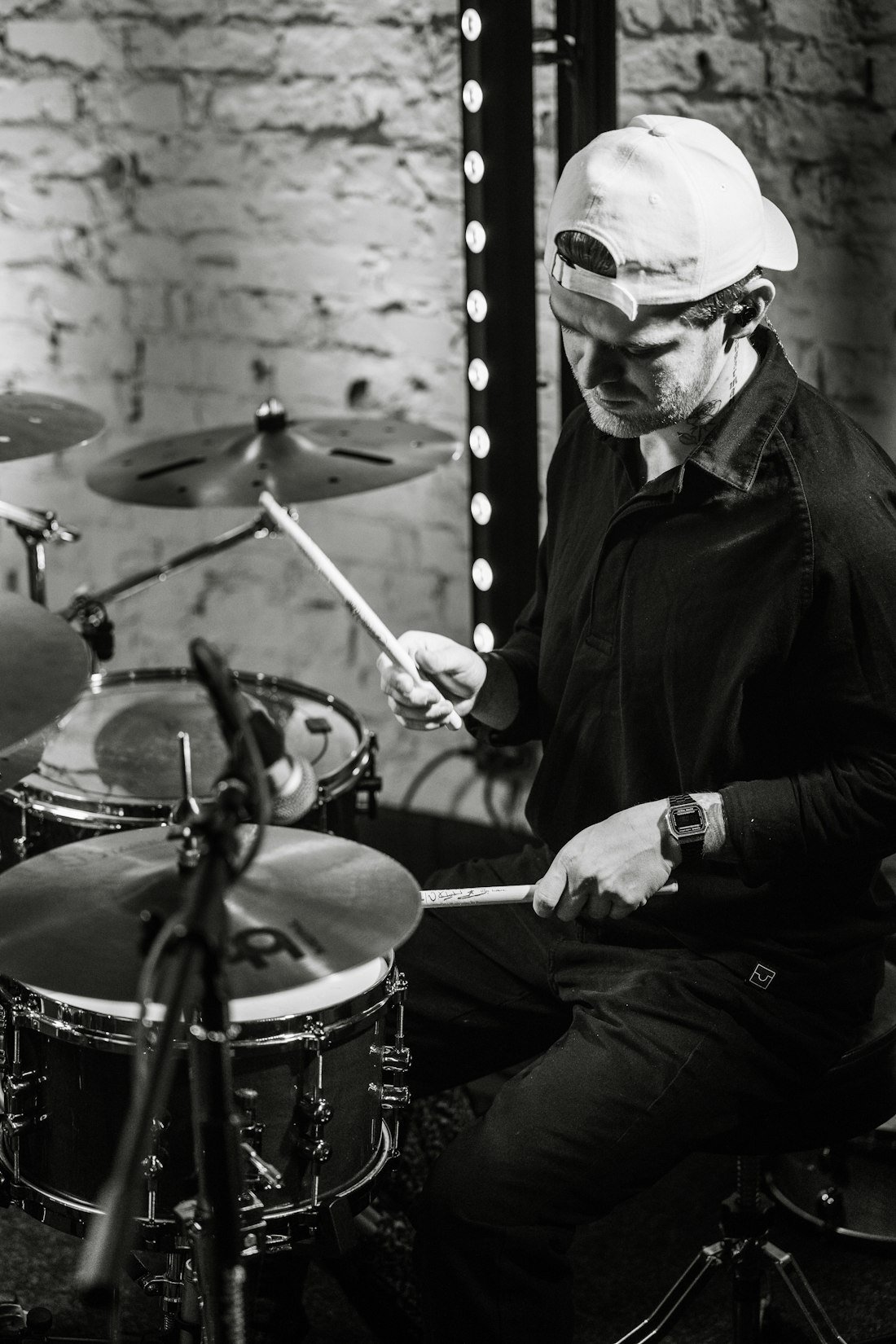 Batteur assis à son kit, baguettes en main